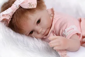 Close-up of lifelike reborn doll with realistic skin texture and floral pink knit outfit