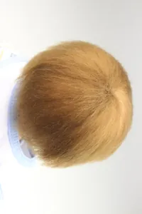 Detailed top view of realistic golden hair and crown swirl on a reborn baby doll