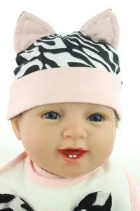 Détail du bonnet et bavoir pour bébé avec motif zébré et petites oreilles roses