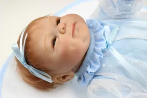 Gros plan d'une poupée Reborn réaliste avec dentelle bleue et cheveux châtains