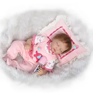 Realistic reborn baby doll in pink elephant outfit sleeping on soft lace pillow