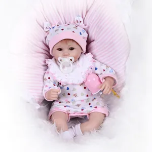 Poupée bébé réaliste avec pyjama à cœurs, bonnet oreilles de lapin et biberon rose