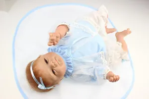 Vue détaillée de la poupée Reborn en tenue de dentelle bleu clair sur un tapis blanc