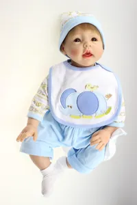 Detailed view of lifelike reborn doll wearing white bib with blue elephant embroidery