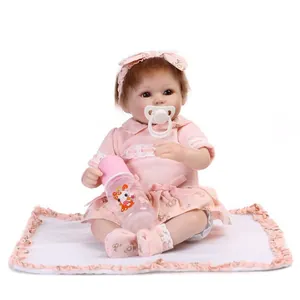 Close-up of a realistic reborn baby doll featuring pink knit top and floral skirt
