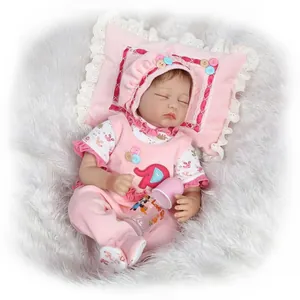 Realistic reborn doll in pink outfit with elephant patch and toy bottle detail