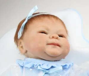 Gros plan d'une poupée reborn faite main avec cheveux bruns et nœud bleu satiné