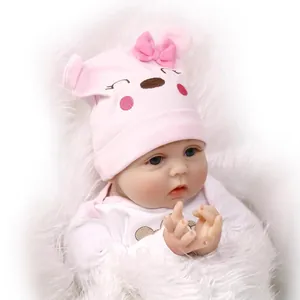 Bambola Reborn realistica con cappello rosa a forma di orso e tutina bianca