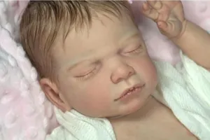 Close-up of lifelike reborn baby doll face with realistic skin and soft hair