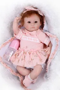 Close-up of realistic reborn doll in floral dress with bottle on plush white fur rug