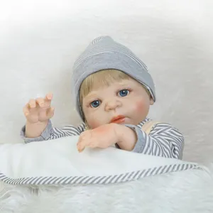 Realistic reborn baby doll with blue eyes and blonde hair in grey striped knit outfit