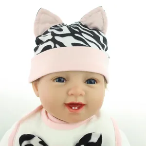 Poupée réaliste avec bonnet en tricot motif zèbre à oreilles de chat et bavoir