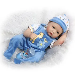 Lifelike baby reborn doll in blue velvet overalls with a small nursing bottle