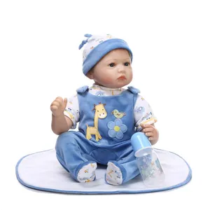 Realistic soft vinyl baby doll in blue velvet overalls with matching hat and feeding bottle