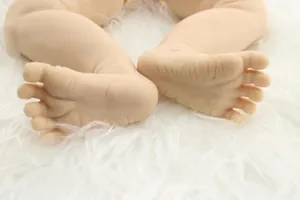 Macro shot of realistic silicone reborn baby doll feet with natural skin texture