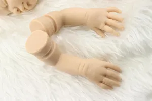 Macro shot of realistic soft silicone baby doll arms and head DIY components on white fur