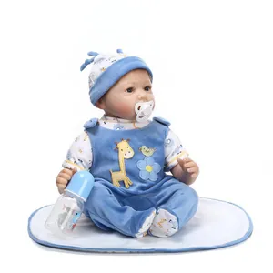 Detail of lifelike baby doll in blue velvet giraffe overalls with a feeding bottle