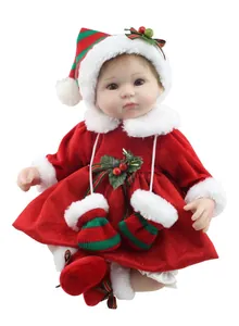 Dettaglio bambola di Natale con vestito di velluto e decorazione di agrifoglio su bianco