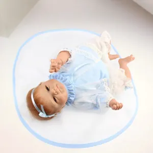 Poupée bébé reborn réaliste faite main en tenue de dentelle bleue sur coussin blanc