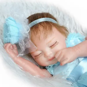Close-up of sleeping reborn doll in light blue lace dress with mesh floral headband