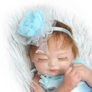 Close-up of realistic reborn baby doll with blue lace flower headband and silk bodysuit