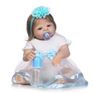 Realistic reborn baby doll in white dress with blue bow, magnetic pacifier, and bottle