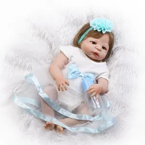 Lifelike reborn baby doll in white bodysuit with blue bow and bottle on plush rug