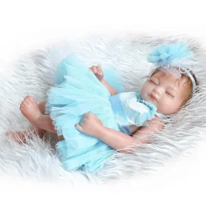 Detailed view of realistic baby doll in blue tutu dress on soft plush surface