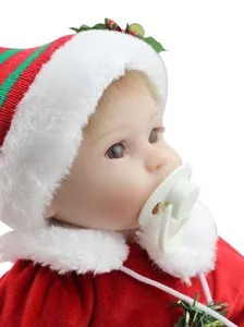 Dettaglio di una bambola reborn natalizia con abito di velluto rosso e cappello