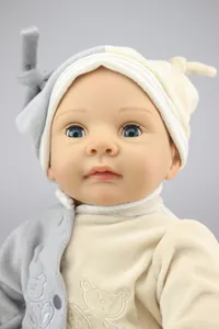 Close-up of realistic reborn doll with deep blue eyes and soft bear embroidery detail