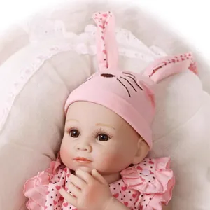 Realistic reborn baby doll in pink rabbit outfit with heart details on lace background