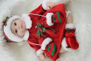 Dettaglio di una bambola reborn realistica con un festoso abito natalizio rosso