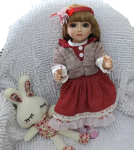 Close-up of a blonde reborn doll in a red polka dot dress with a floral bunny plush