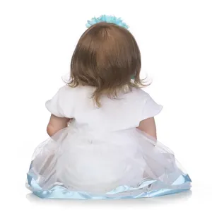 Detail view of lifelike baby doll with curly brown hair wearing a blue flower headband