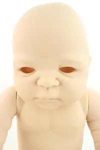 Close-up of unpainted vinyl reborn doll kit showing head and shoulder torso details
