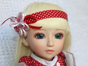 Close-up of red polka dot doll headband with pink satin flower and matching dress