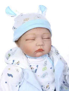 Close-up of a sleeping reborn baby doll in a blue bear patterned onesie and hat