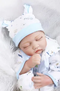 Close-up of realistic newborn doll sleeping on white plush with soft skin details