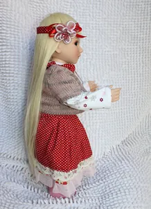 Close-up detail of a cute princess doll featuring golden hair and polka dot dress