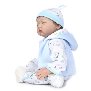 Close-up of sleeping reborn baby doll in blue bear outfit with realistic soft skin texture