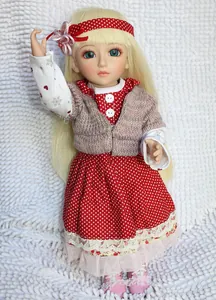 Detailed close-up of a BJD princess doll wearing a red polka dot dress and pink cardigan