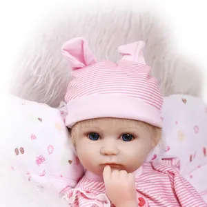 Muñeca bebé reborn realista con ojos azules y gorro de orejas de conejo rosa