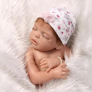 Bambola reborn realistica che dorme con cappello floreale e braccialetto di perle su peluche