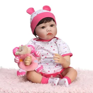 Lifelike reborn baby doll in pink floral bodysuit with a plush elephant toy