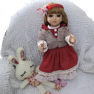 Cute BJD princess doll in red polka dot dress with toy rabbit on white plush rug