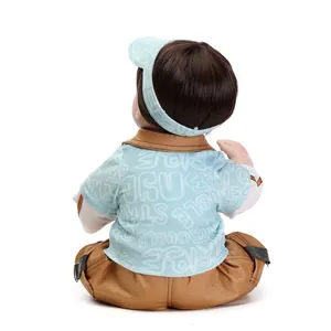 Back view of lifelike reborn doll with dark brown hair and blue striped sun hat