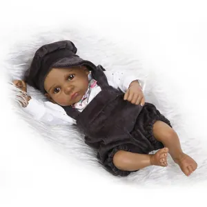 Lifelike black baby reborn doll wearing white lace shirt and brown corduroy overalls