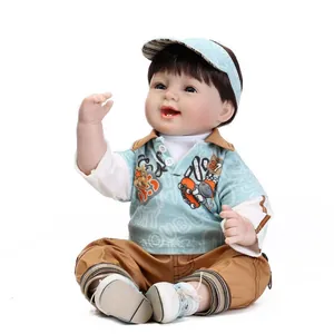 Lifelike reborn baby boy doll with brown hair and blue eyes in blue polo and striped hat