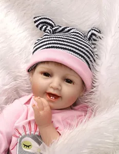 Gros plan d'une poupée reborn réaliste souriante avec bonnet en tricot rose