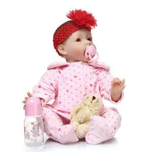 Realistic reborn baby doll in pink floral outfit with pacifier and bear toy accessories